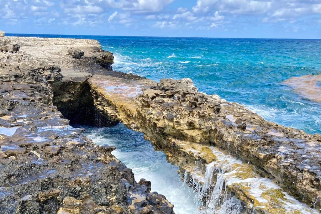 The naturally formed arch over the sea called Devil's Bridge in Antigua with waves breaking on it