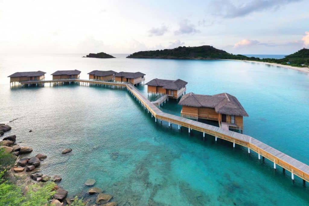 Water bungalows at the Royalton Antigua Resort with two small green islands in the background.