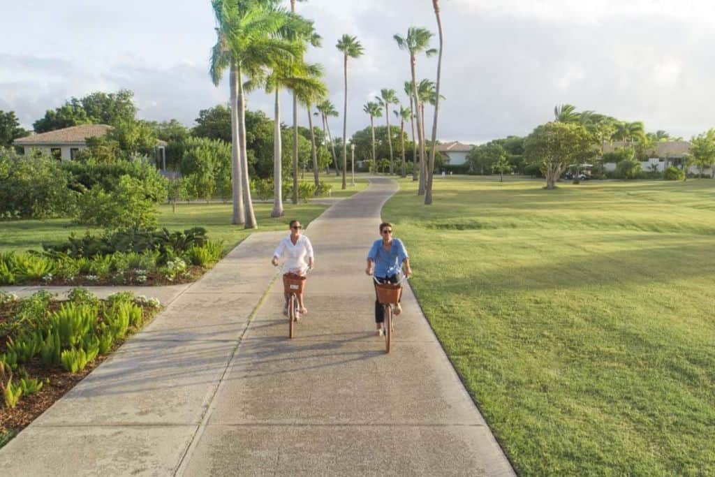 A man and a woman on bikes cycling on a path on Long Island Antigua Barbuda.