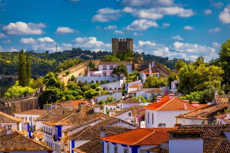 The main castle of Obidos with the colourful town in front of it. One of the best day trips from Lisbon