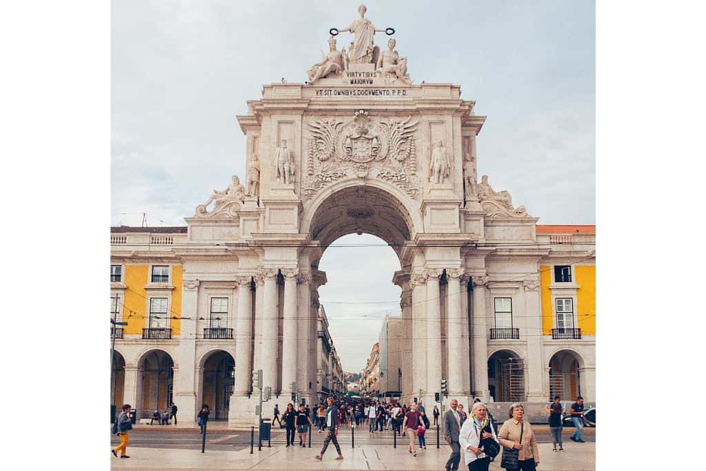 A view of a main plaza and it's large stone gate in Baixa which is the best area to stay in Lisbon.