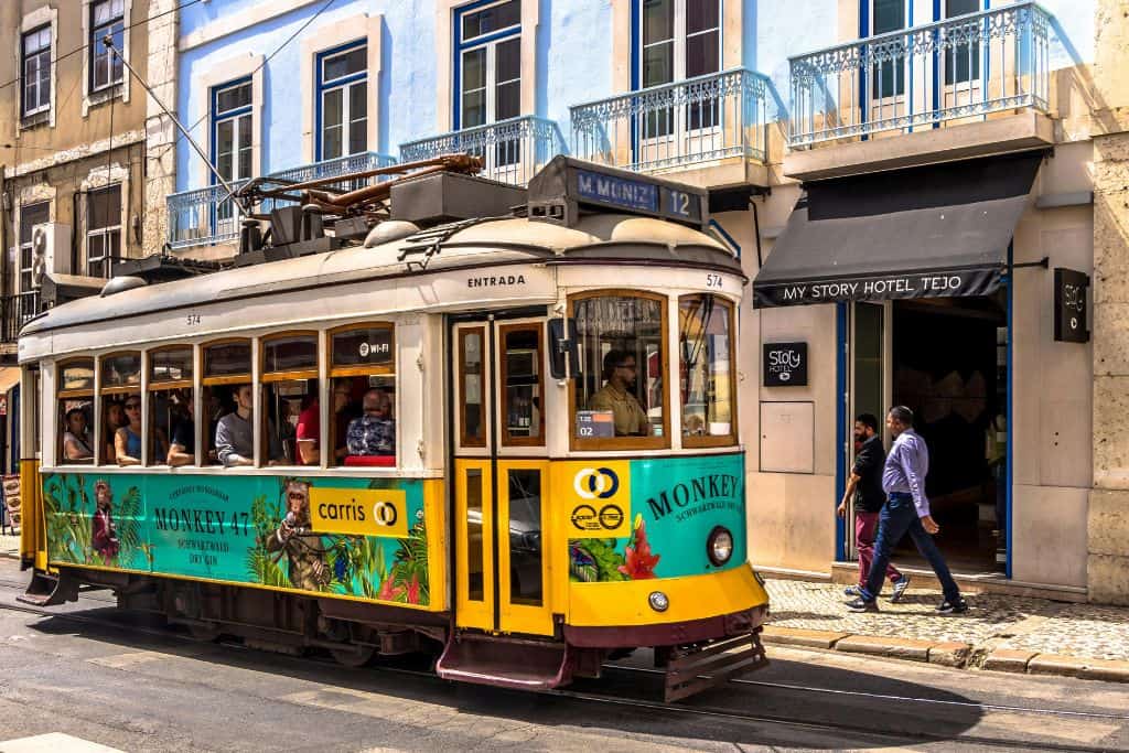 A brightly coloured yellow tram in Lisbon in Alfama which is one of the best area in Lisbon to stay.