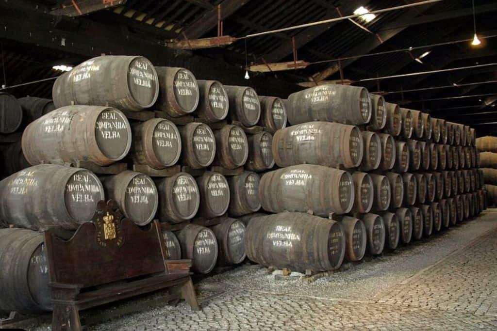Rows and rows of old port barrels with Real Companhia Velha written on them. Real Companhia Velha is one of the best wineries in Porto Portugal.