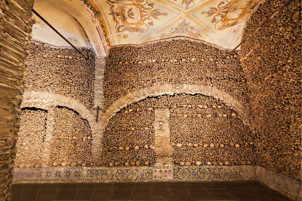 The inside of the Evora Bone Chapel in Portugal.  You can see the individual bones are stacked up against the sides of the interior of the building.  It's very macabre but also beautiful and should be everyones bucket list.