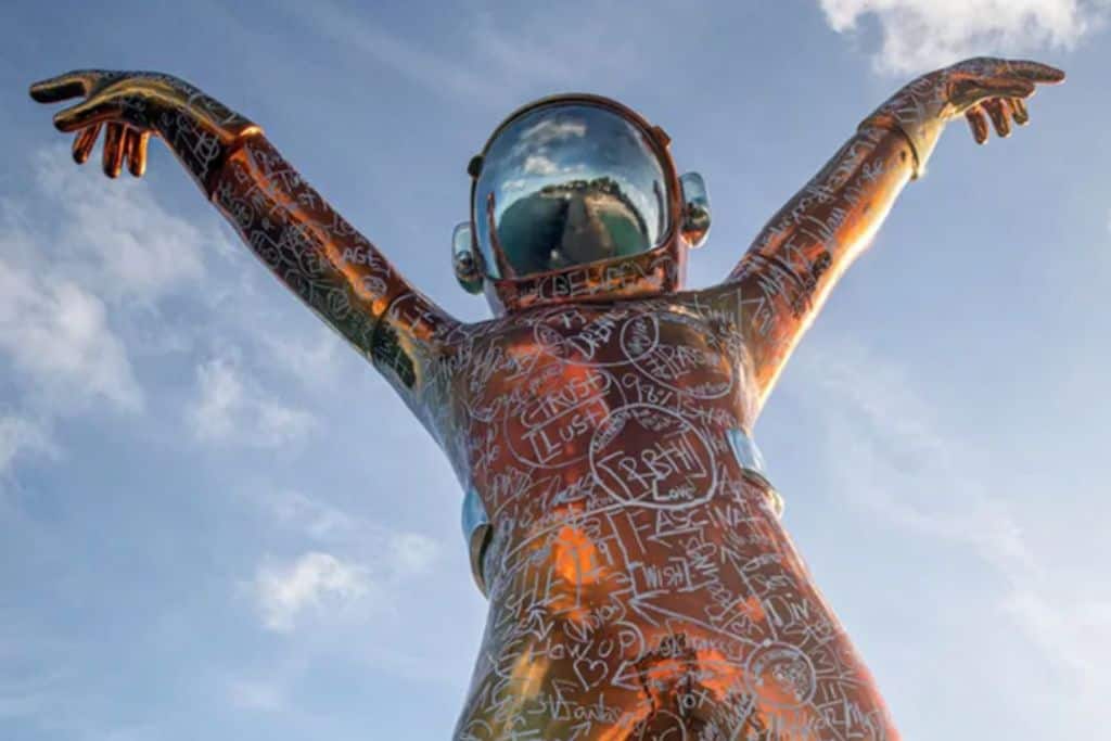 A big spaceman statue in a brass colour with graffiti on it called Boonji Man from Hodges Bay Resort in Antigua.