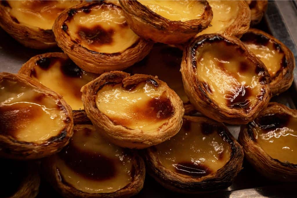 Lots of pasteis de nata on one plate, these are the Portuguese tarts that everyone loves.