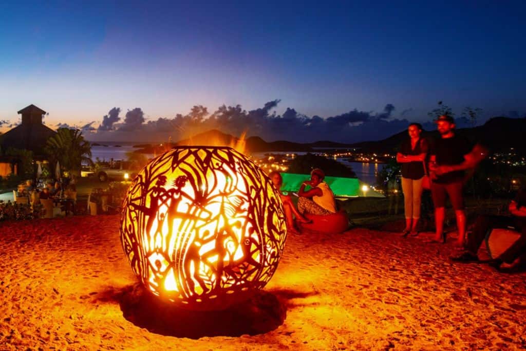 Firepit with people dancing on the beach at Sugar Ridge Resort in Antigua.