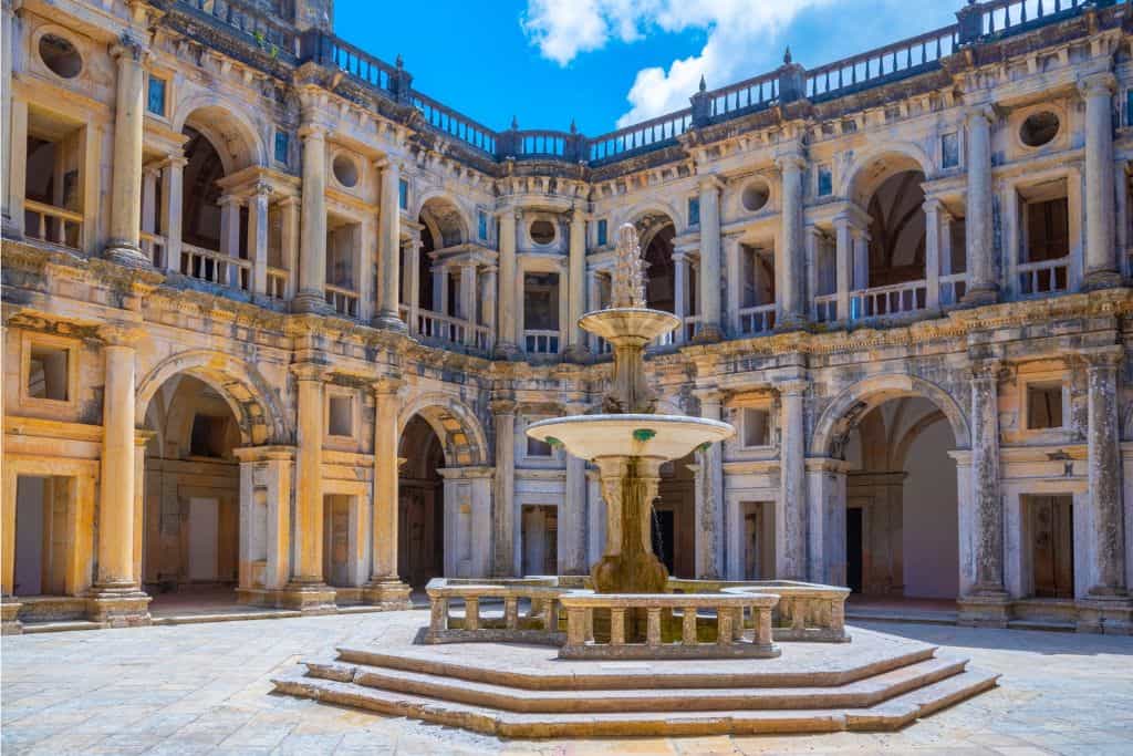 The main square of Tomar in Portugal which is a selection of intricately carved buildings set out around a fountain.