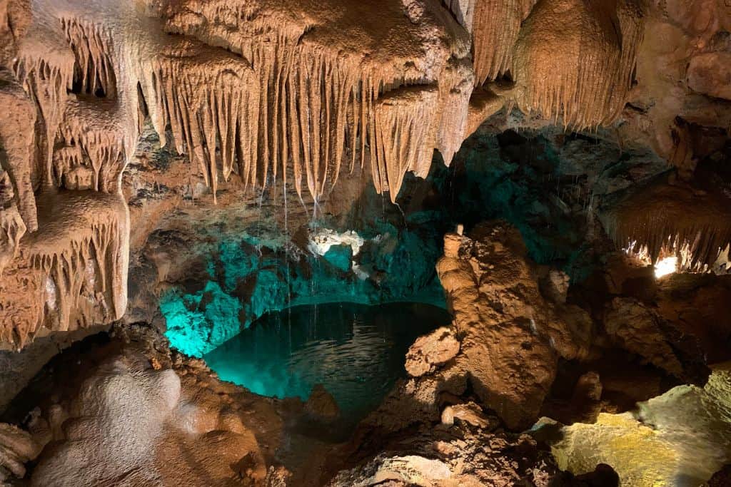 The inside of some underground caves in central Portugal called Grutas de Mira de Aire.  In the middle of the photo there is an underwater lake with Stalactites coming down into it.