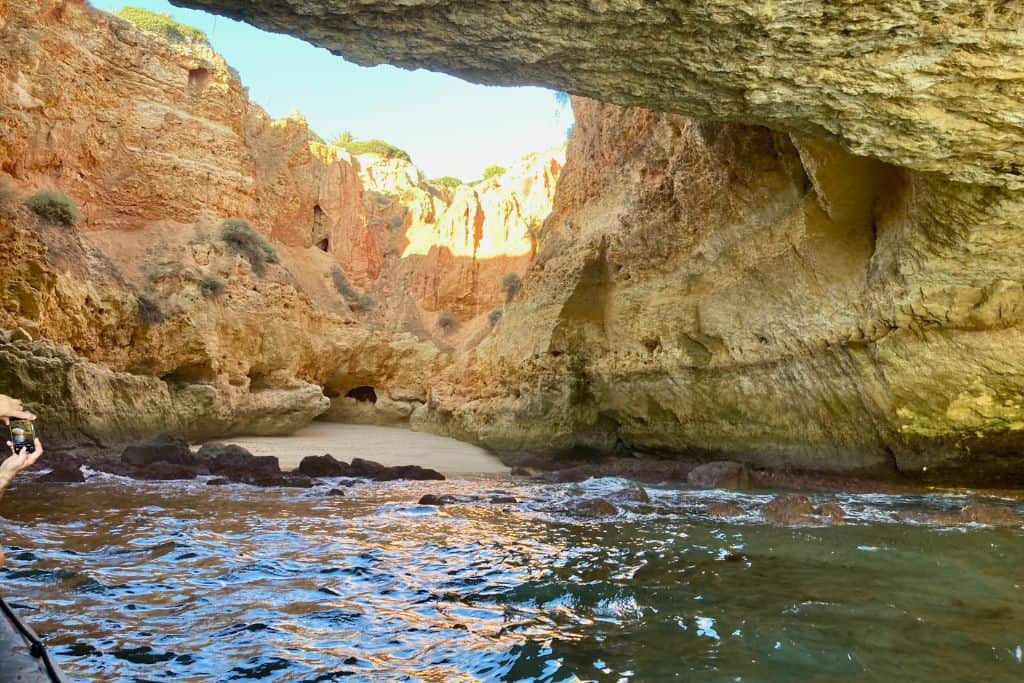 The photo is take from the water looking back at one of the cave beaches in The Algarve.  The light is streaming in through. whole in the roof of the cave and hitting the water below.