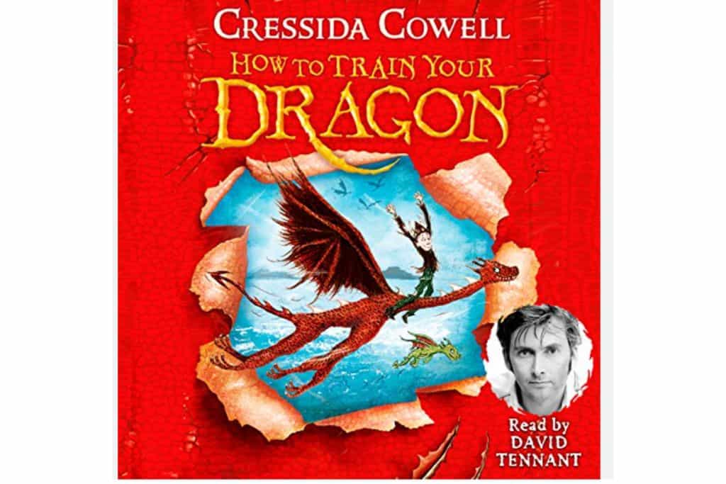 The cover of How to Train Your Dragon audiobook. On the front it looks like its' been ripped and is showing a scene of. dragon flying through the air with a boy on it.  On the bottom right of the cover is a photo of David Tennent who reads the story.