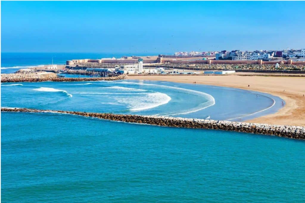 This is an image of the beach in Rabat with it's sea wall coming in from the right hand side. In the distance you can see the buildings of Rabat.