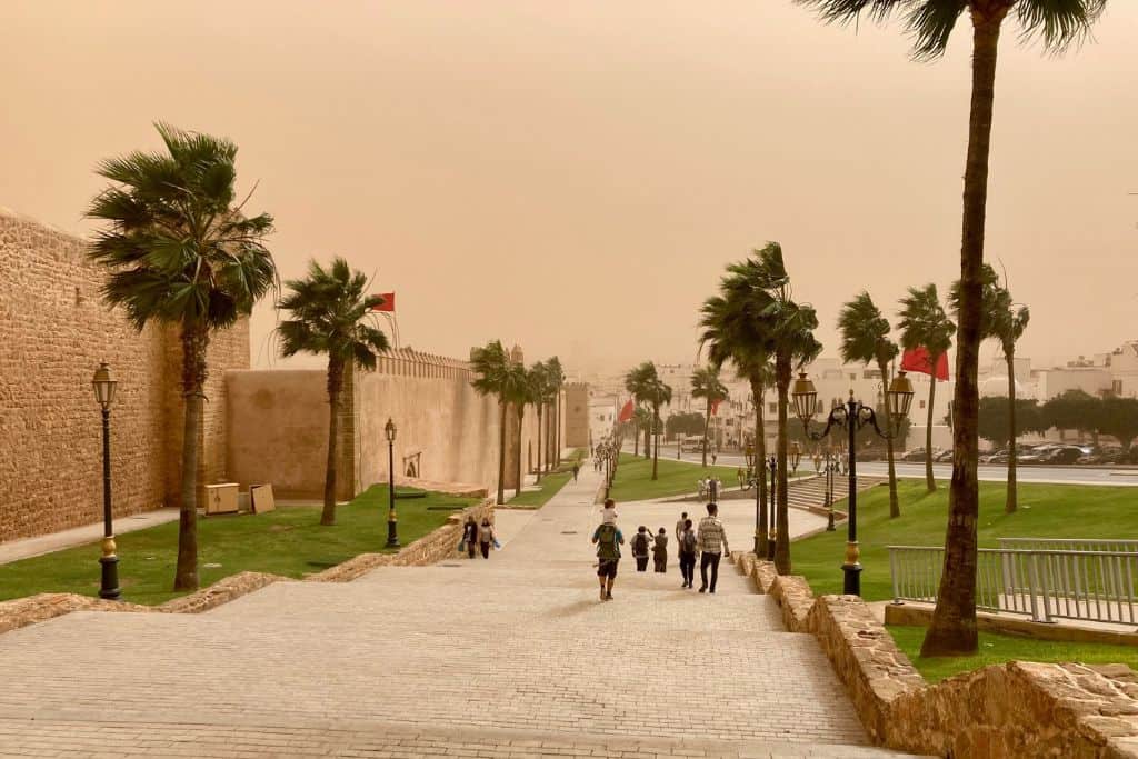 This is the image of some steps leading down from the medina in Rabat.  There is a dust storm and several people are walking down the steps with their back to the photographer and the picture has a dusty tinge to it. 