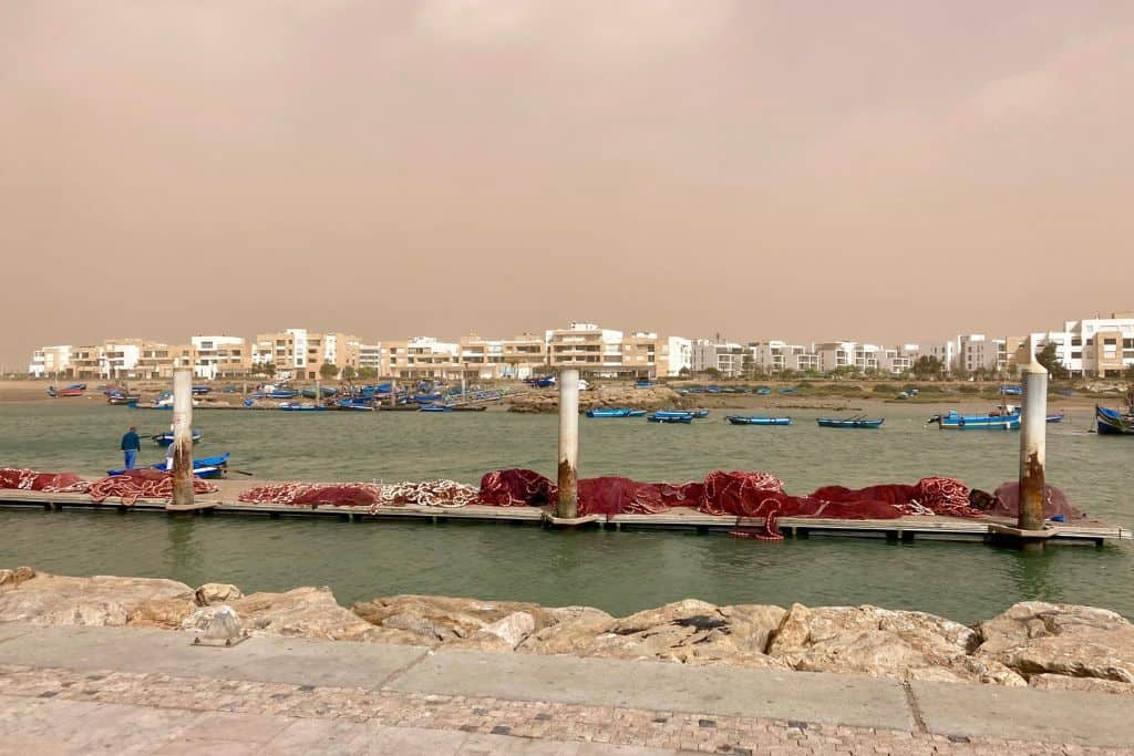 The photo is taken from Rabat looking out over the river to the city of Sale. In the water are many blue ferry boats that are used to take people from Rabat to Sale.