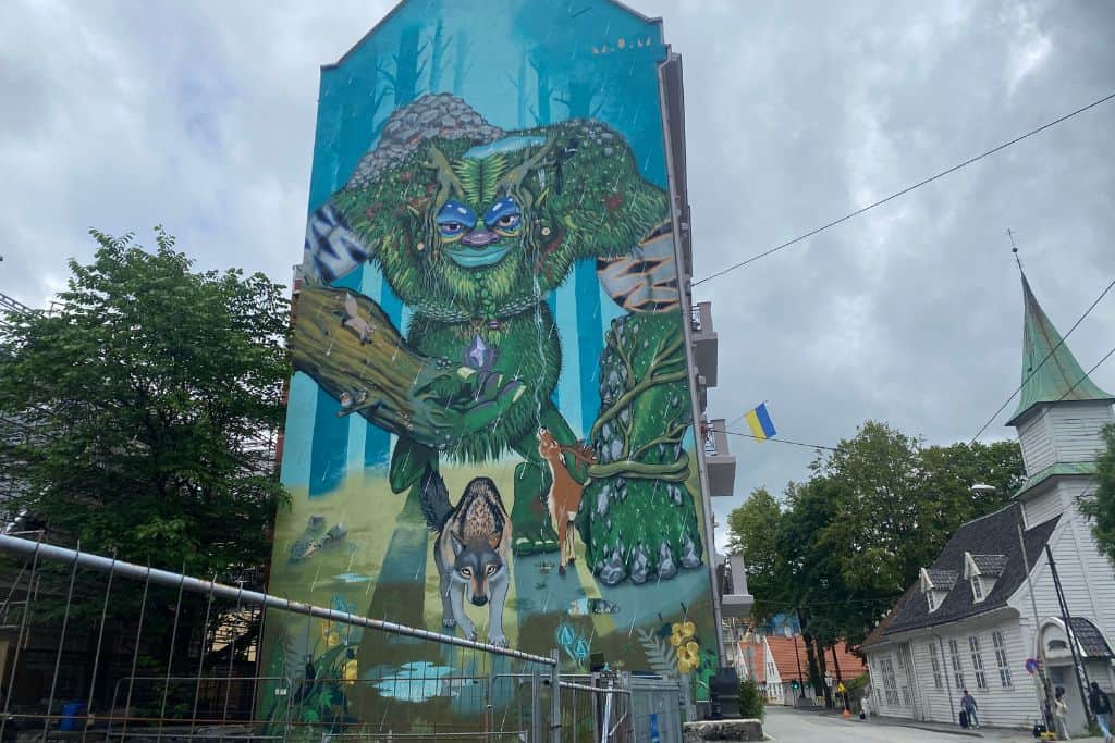 A very large piece of street art in Bergen that is the image of a troll surrounded by woodland animals such as a deer and fox.