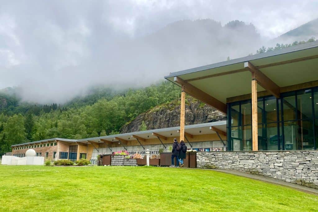 A large stone, wood and glass building that is a fjord museum in Geiranger in Norway.