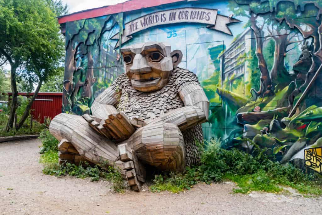 This is a photo of a giant troll made of wood from old pallets that it is in Freetown Christiania in Copenhagen by an artist called Thomas Dambo.