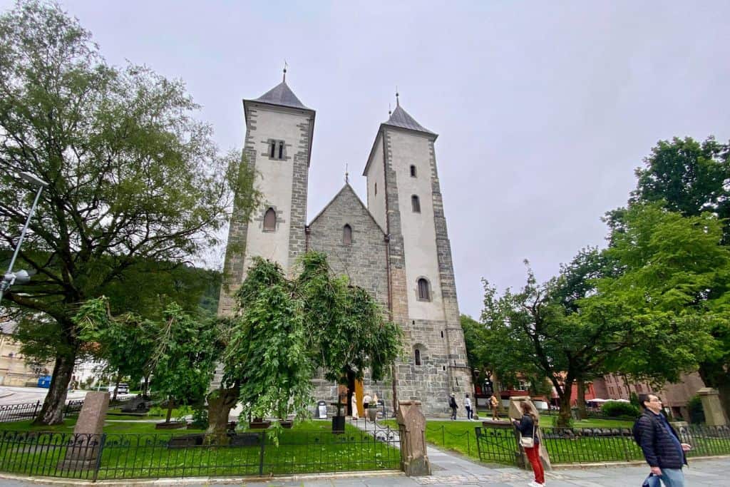 This is the stone and plaster front of the St Mary's Church in Bergen. Surrounding the church are trees and bushes. 
 You can easily visit this as part of one day in Bergen.